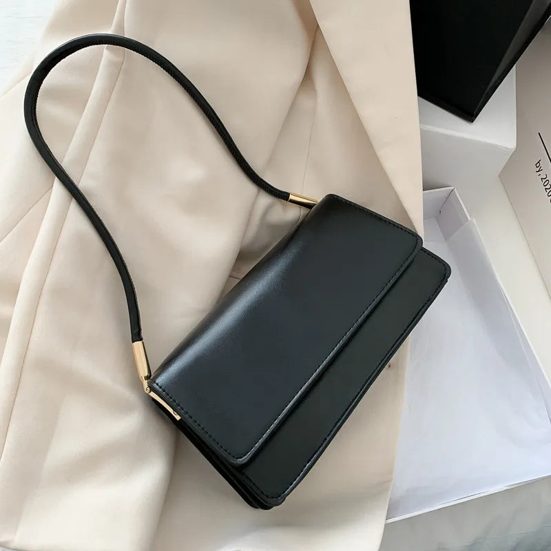 Slim rectangular flap shoulder bag with gold-tone strap accents — black on cream fabric | BTendance