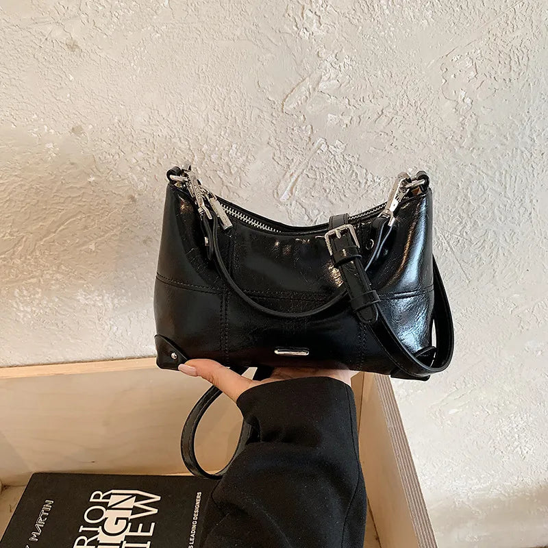 Glossy shoulder bag with strawberry charm – Black bag, side angle in hand | BTendance