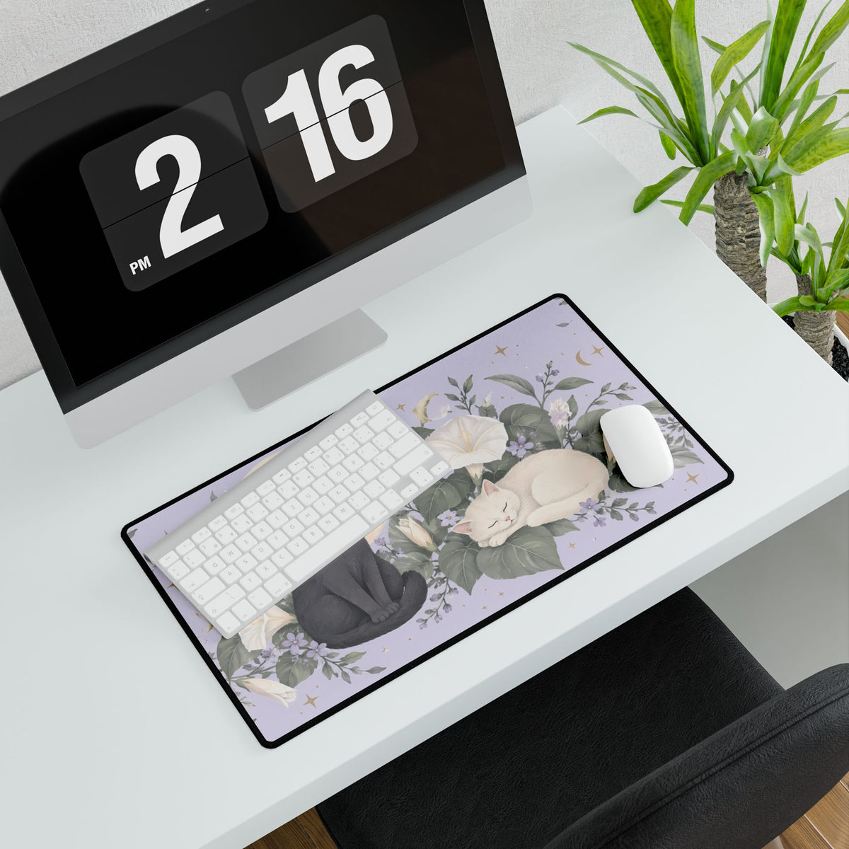Moonflower Cats Desk Mat, 23.6 × 13.8 in, angled computer desk mockup with plant.
