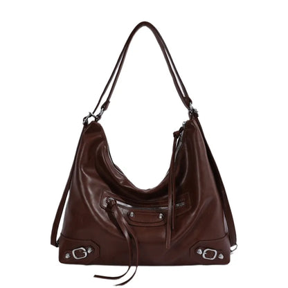 Slouchy shoulder bag with front zip and buckle details — warm brown on white background | BTendance