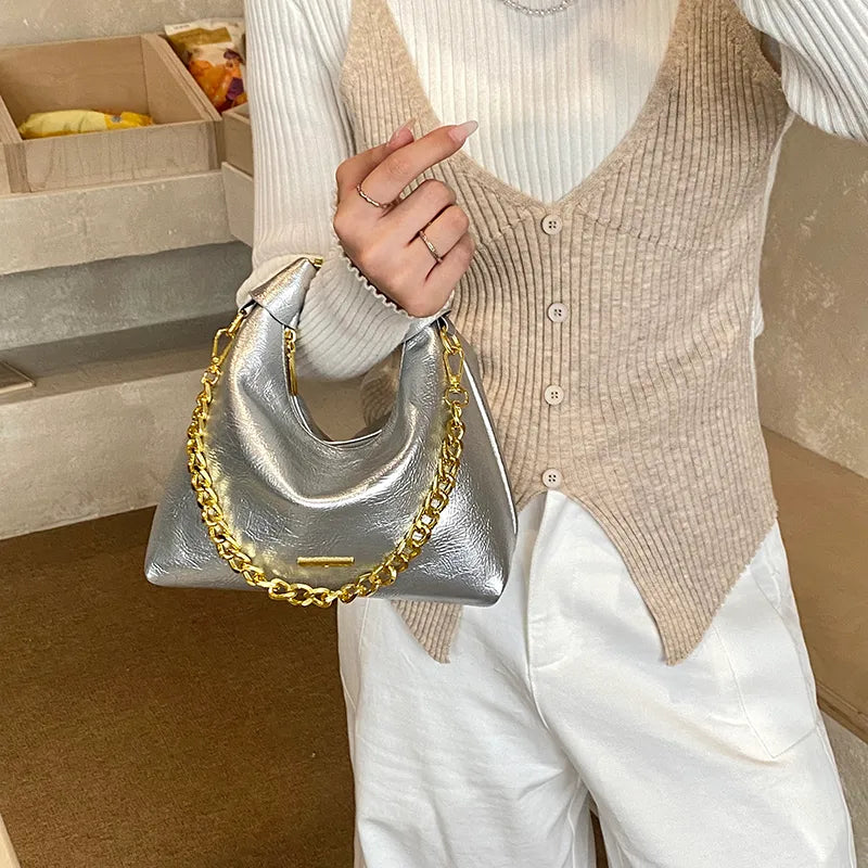 Soft handbag with gold tone chain – Silver bag held at the side | BTendance