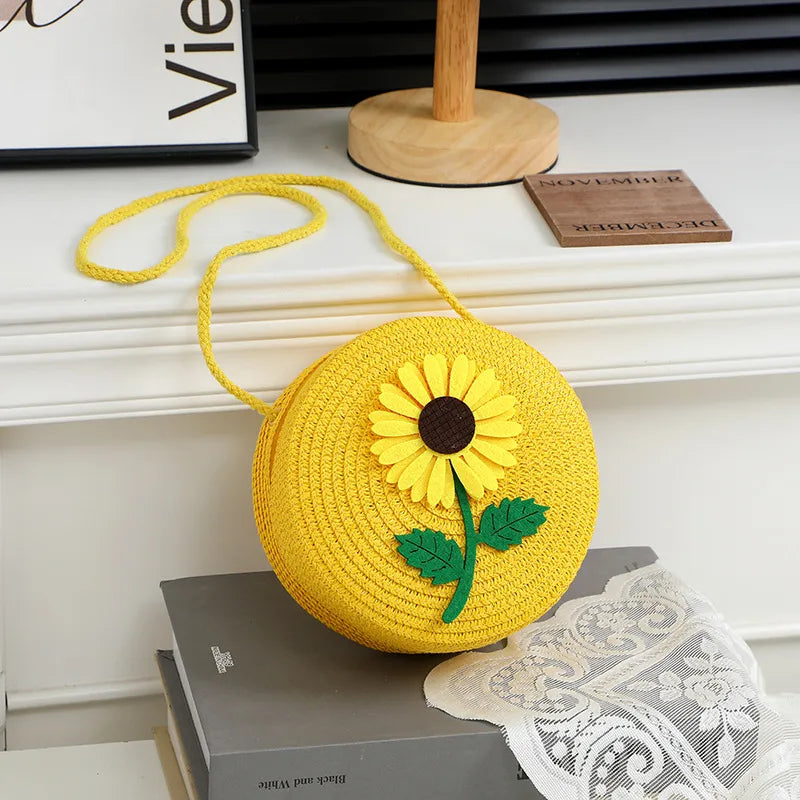 Round woven sunflower crossbody bag – Yellow stem and leaf sunflower bag on a display table | BTendance