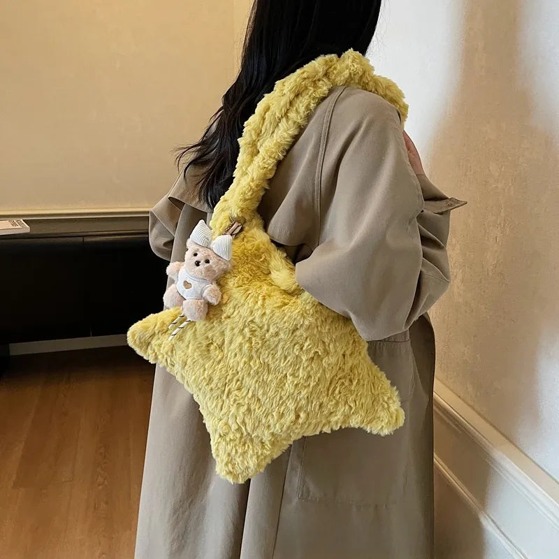 Star-shaped plush shoulder bag with small hanging charm — yellow worn on shoulder | BTendance