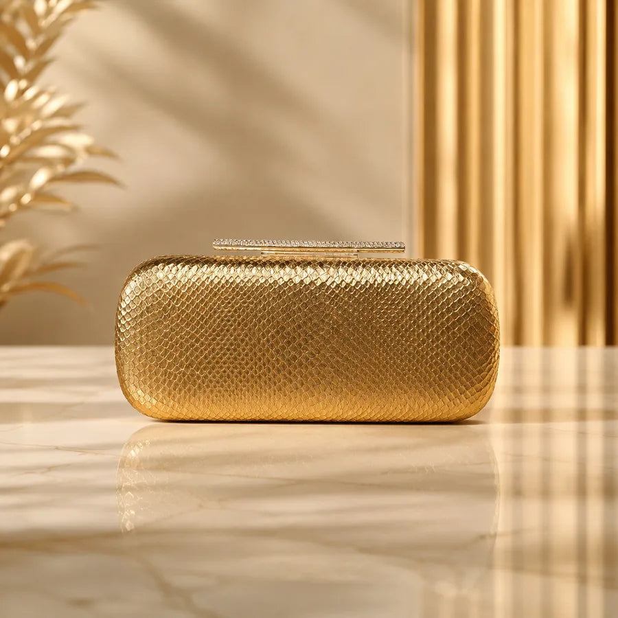 Snakeskin-texture rectangular evening clutch with bar clasp — gold on marble table | BTendance
