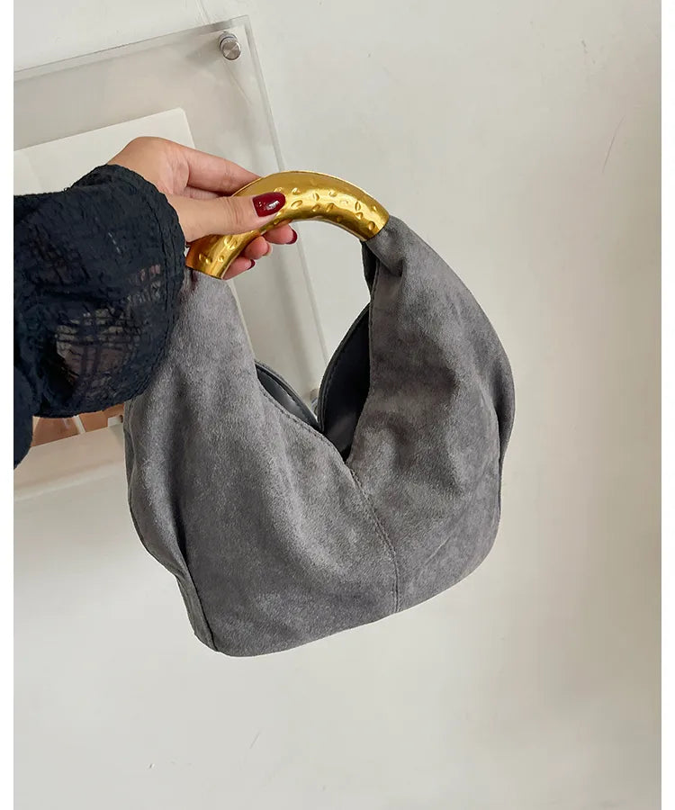 Suede-look bucket handbag with curved gold-tone handle — grey held by handle | BTendance