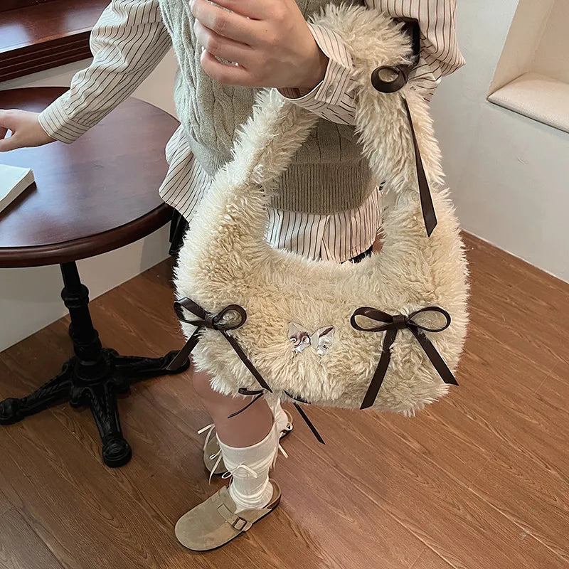 Shaggy plush shoulder bag with ribbon bows — cream held by model | BTendance