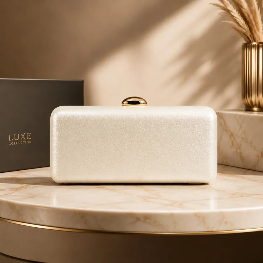 Rectangular evening clutch with oval metal clasp — ivory on marble display | BTendance