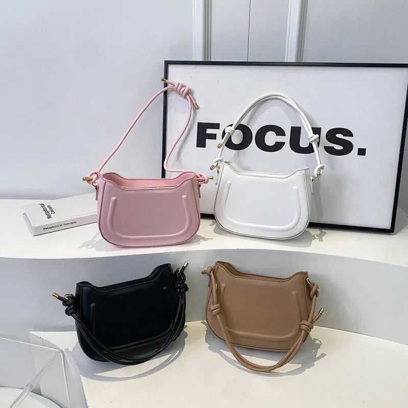 Curved shoulder bag with outlined front panel and knotted strap — four colors arranged on display | BTendance