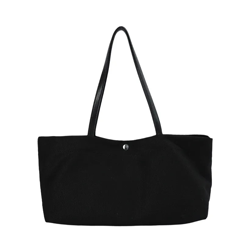 Wide canvas tote with contrasting dark shoulder handles — black front view on white background | BTendance