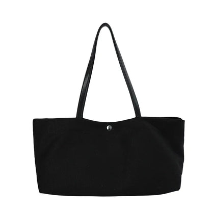 Wide canvas tote with contrasting dark shoulder handles — black front view on white background | BTendance