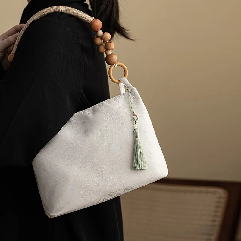 Floral shoulder bag with beaded handle – Ivory bag with green tassel, worn on shoulder | BTendance