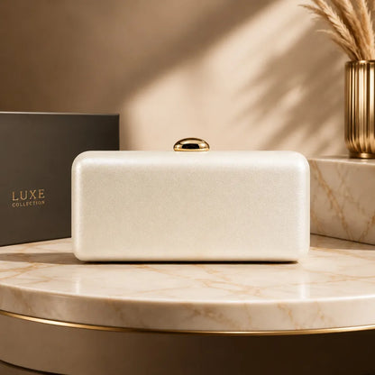 Rectangular evening clutch with oval metal clasp — ivory on marble display | BTendance