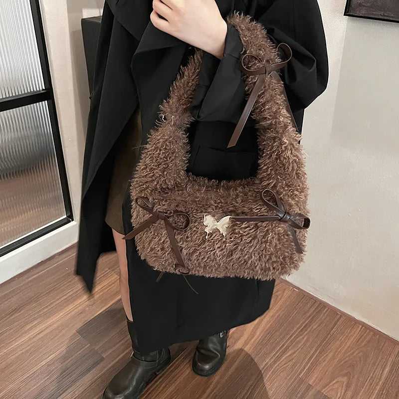 Shaggy plush shoulder bag with ribbon bows — brown held by model | BTendance