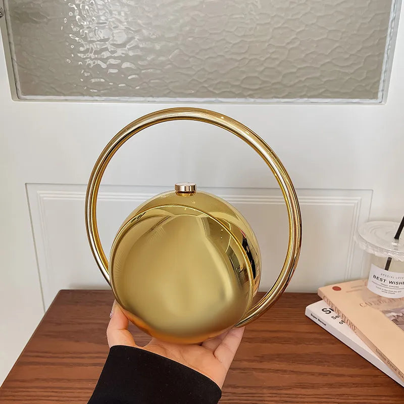 Round Acrylic Orb Bag with Faceted Ring Handle – Gold held for scale | BTendance