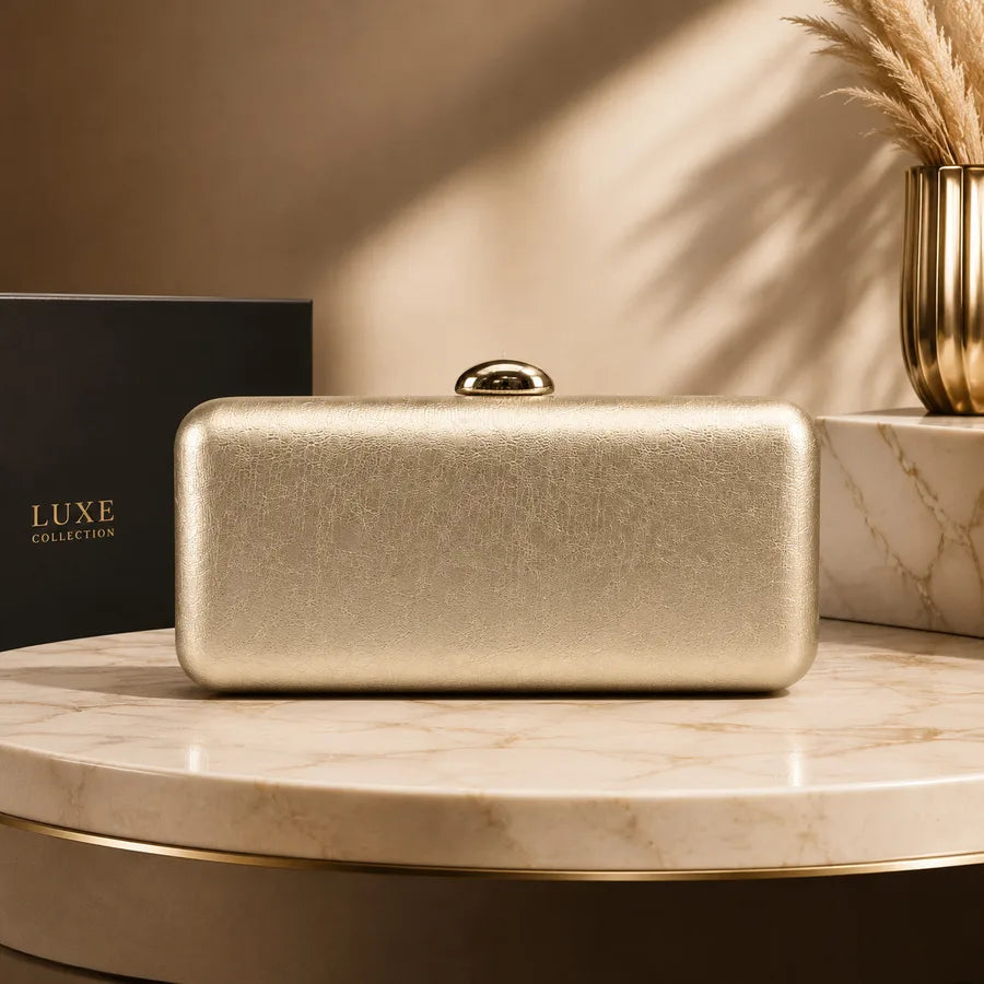 Rectangular evening clutch with oval metal clasp — gold on marble display | BTendance