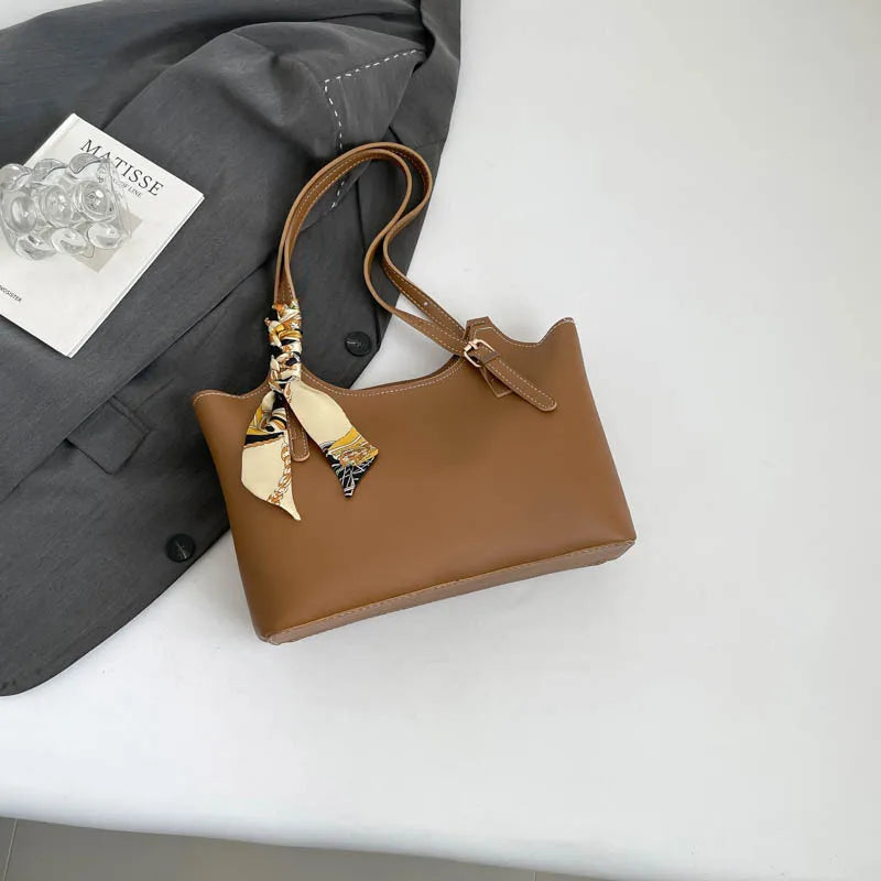 Shoulder tote bag with patterned scarf – Tan bag arranged beside a blazer | BTendance