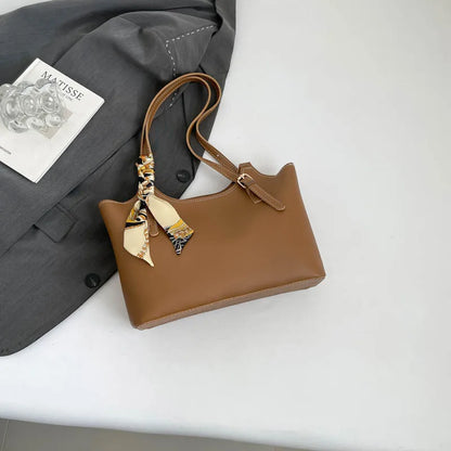Shoulder tote bag with patterned scarf – Tan bag arranged beside a blazer | BTendance