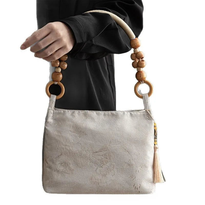 Floral shoulder bag with beaded handle – Cream bag held by its beaded handle | BTendance