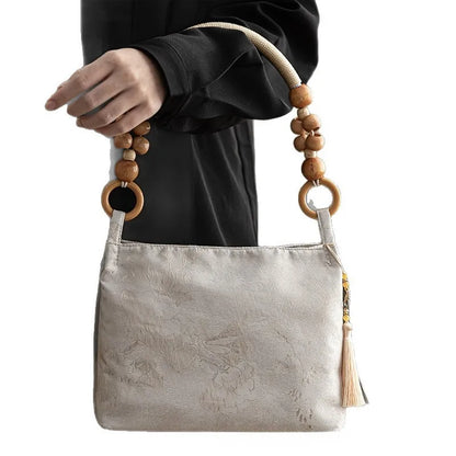 Floral shoulder bag with beaded handle – Cream bag held by its beaded handle | BTendance