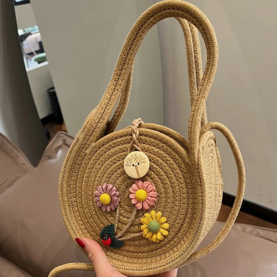 Round woven handbag with flower decoration – Tan flower bag held by its base | BTendance