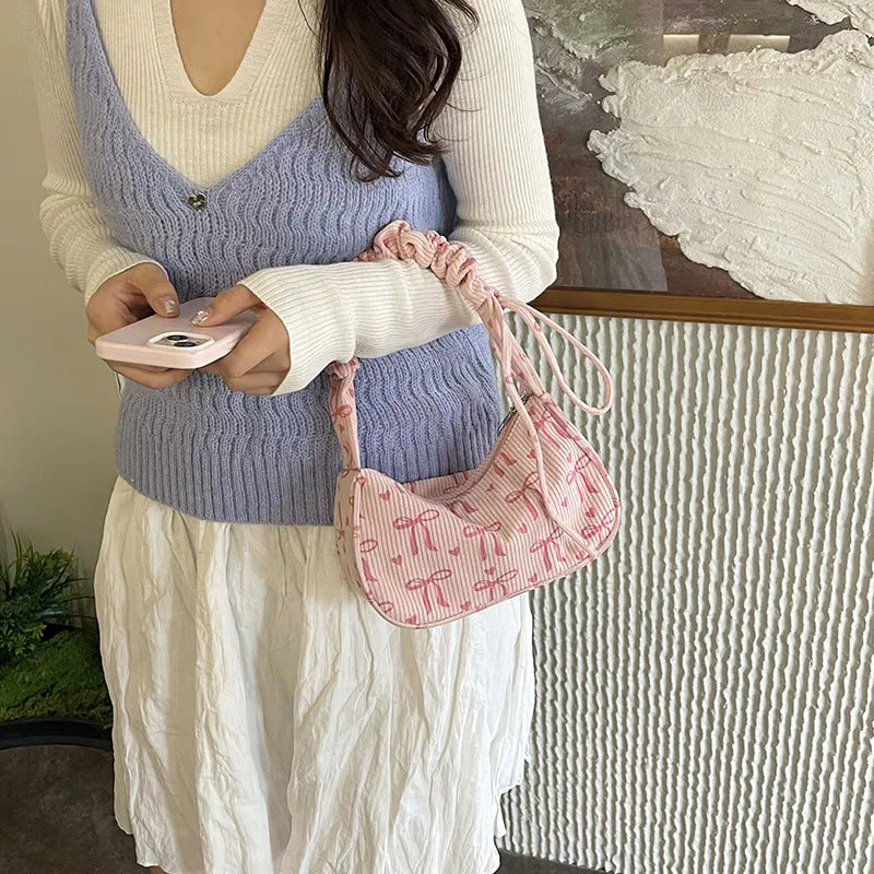 Bow-print corduroy shoulder bag with gathered handle — pink worn on shoulder | BTendance