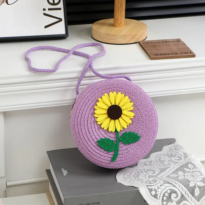 Round woven sunflower crossbody bag – Purple stem and leaf sunflower bag on a display table | BTendance