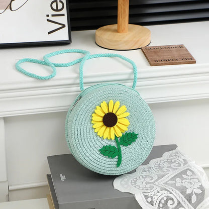 Round woven sunflower crossbody bag – Blue stem and leaf sunflower bag on a display table | BTendance
