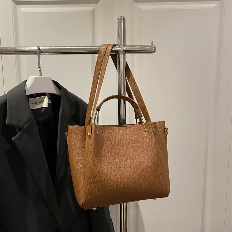Textured bucket handbag with contrasting dark handles — tan hanging on clothing rack | BTendance