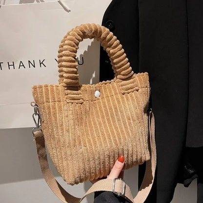 Ribbed plush handbag with rounded handles and long strap — tan held in one hand | BTendance