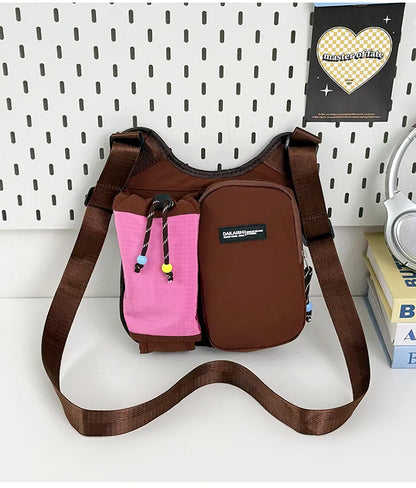 Crossbody bag with mesh bottle pocket and front zip pouch — brown with pink pocket on display | BTendance