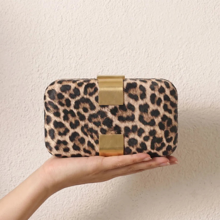 Rectangular evening clutch — leopard print held in one hand | BTendance