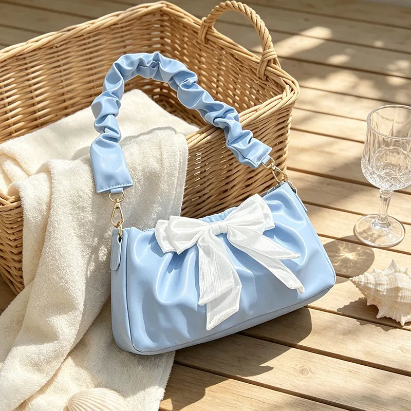 Bow-detail shoulder bag with gathered handle — blue with white bow beside wicker basket | BTendance