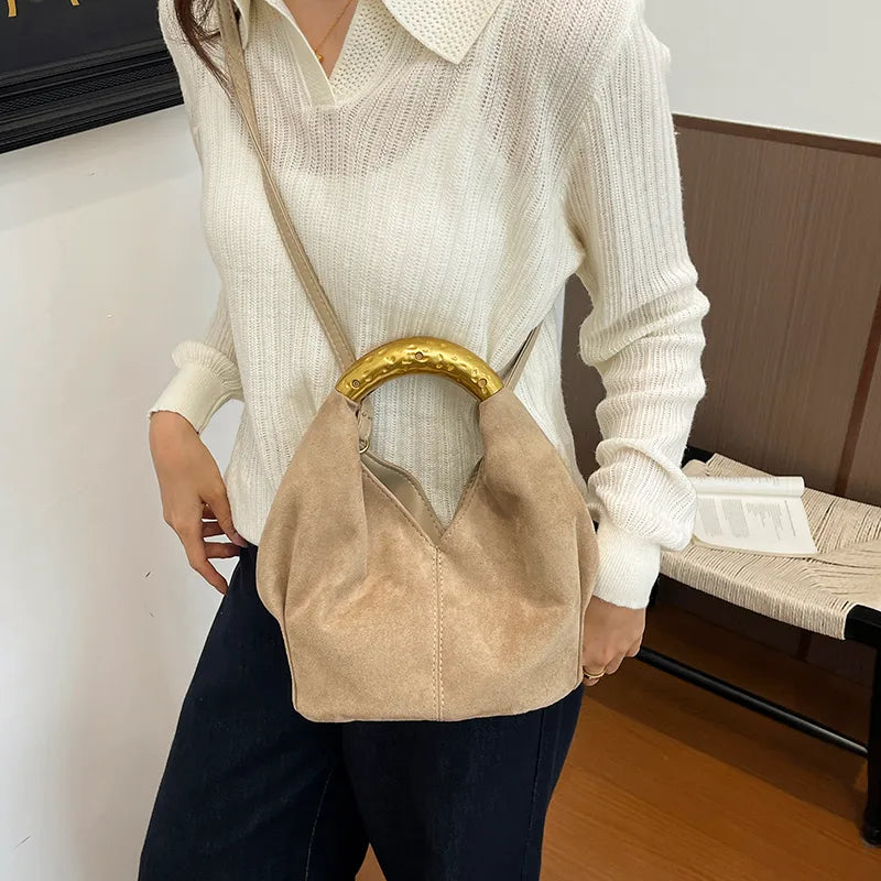 Suede-look bucket handbag with curved gold-tone handle — beige worn crossbody | BTendance