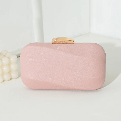 Rounded rectangular evening clutch with metal clasp — pink front view on table | BTendance