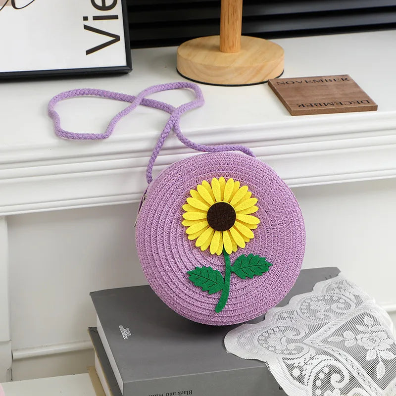 Round woven sunflower crossbody bag – Purple stem and leaf sunflower bag on a display table | BTendance