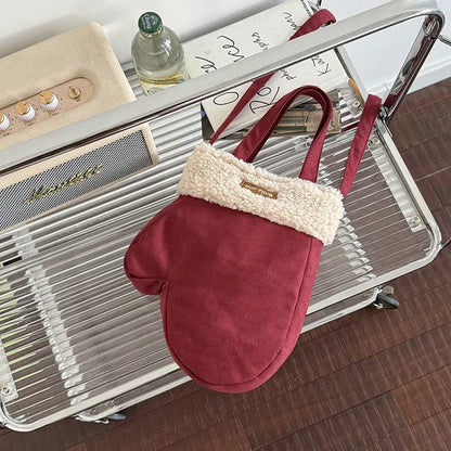 Mitten-shaped crossbody bag with contrasting plush panel — burgundy with cream cuff hanging from shelf | BTendance