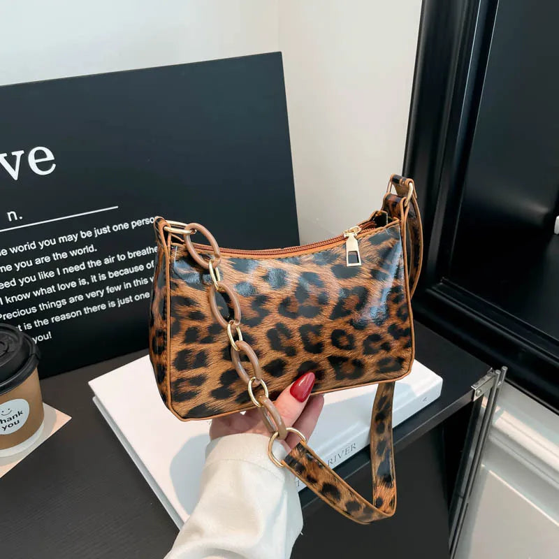 Leopard print bag with chain detail strap – Brown leopard bag held in one hand | BTendance