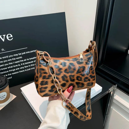 Leopard print bag with chain detail strap – Brown leopard bag held in one hand | BTendance