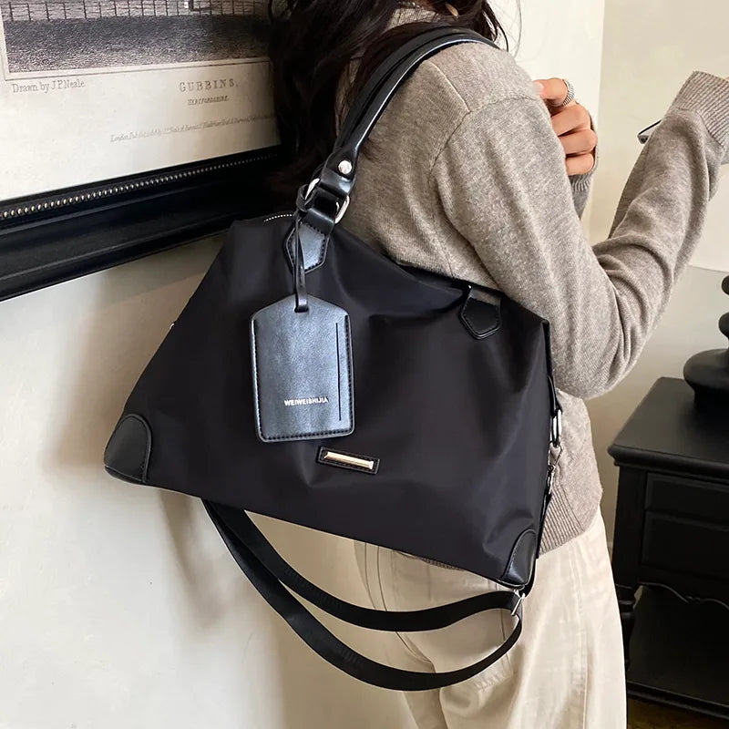 Nylon handbag with contrast handles and shoulder strap — black worn on shoulder | BTendance