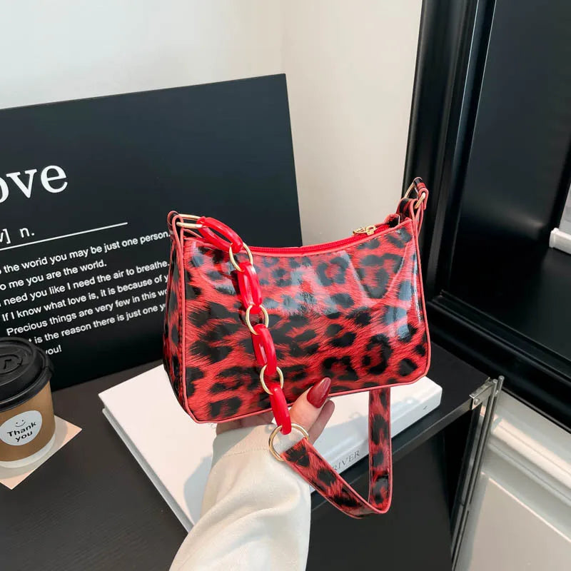 Leopard print bag with chain detail strap – Red leopard bag held in one hand | BTendance
