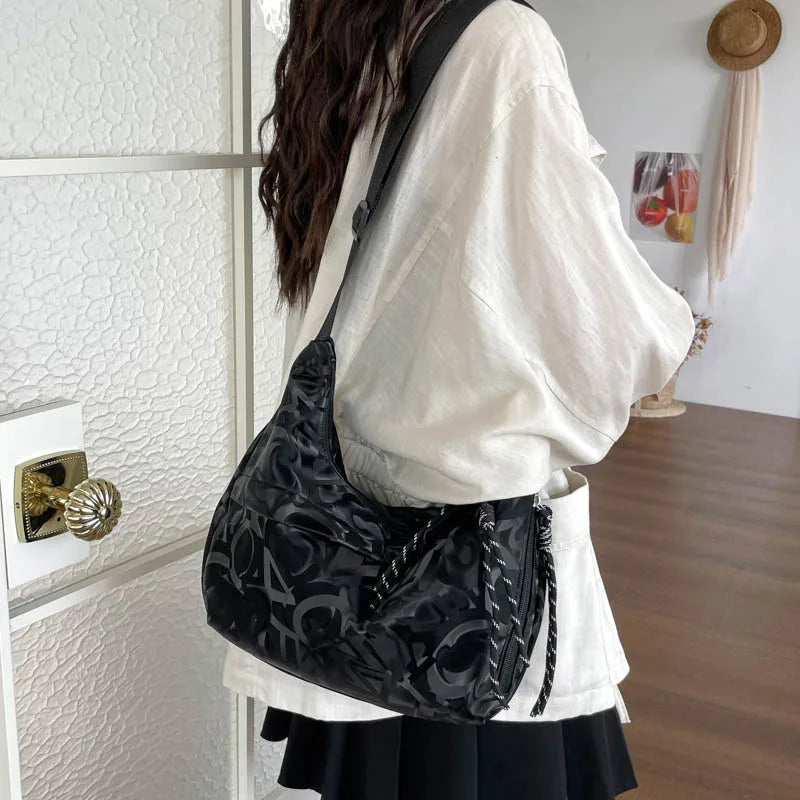 Patterned shoulder bag with braided front detail — black worn on shoulder | BTendance