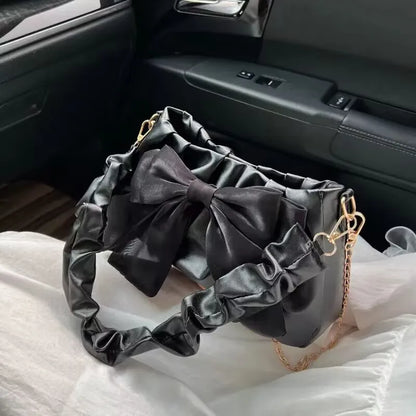 Bow-detail shoulder bag with gathered handle — black with matching bow on car seat | BTendance