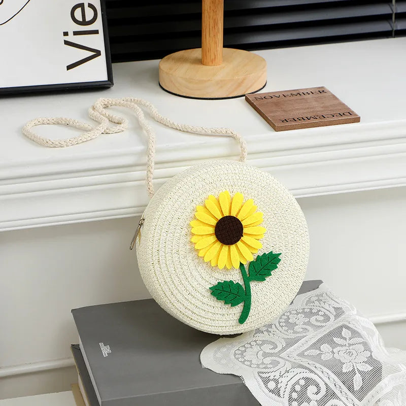 Round woven sunflower crossbody bag – White stem and leaf sunflower bag on a display table | BTendance