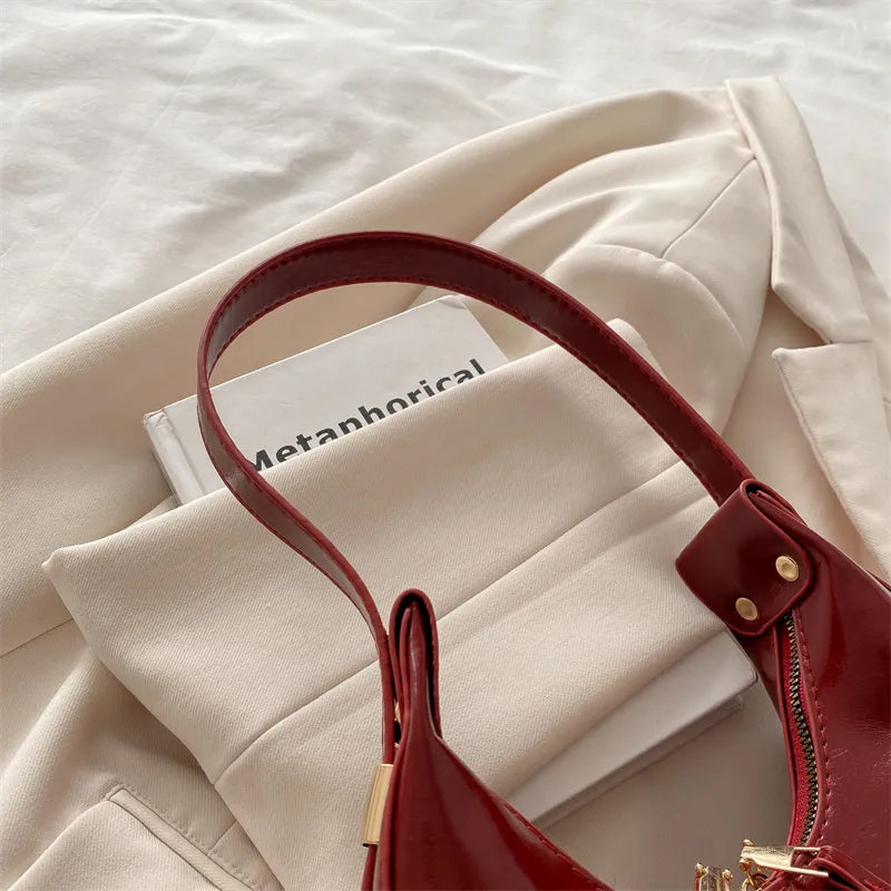Curved zip shoulder bag – Close view of burgundy shoulder strap and zip | BTendance