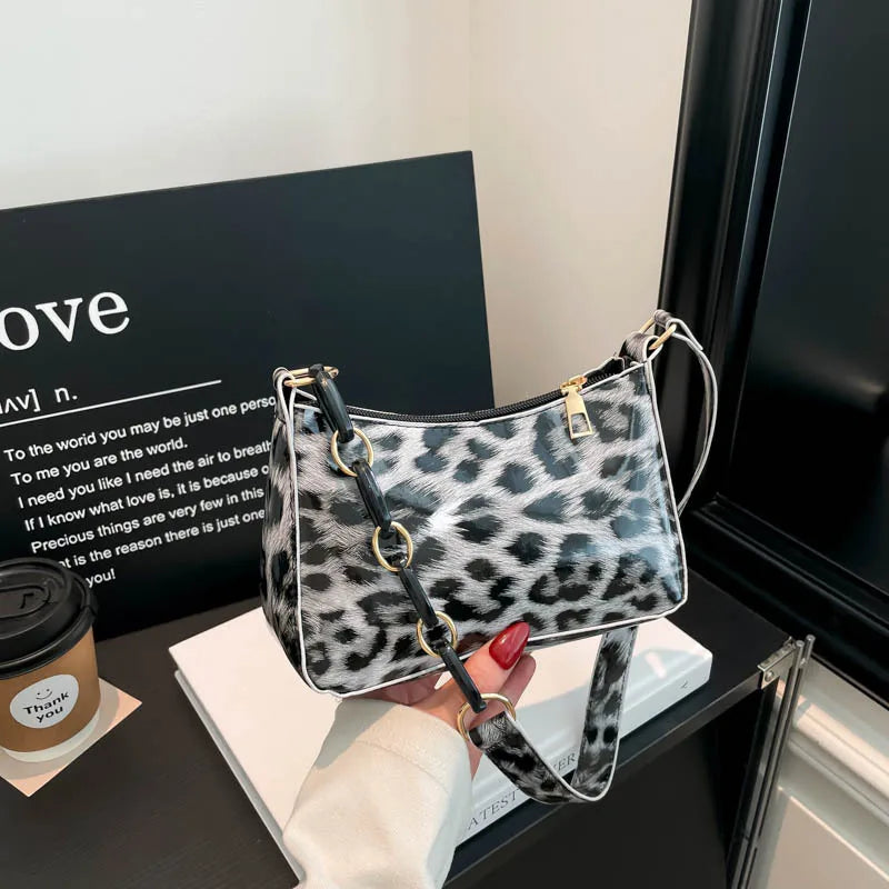 Leopard print bag with chain detail strap – Grey leopard bag held in one hand | BTendance