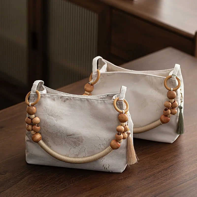 Floral shoulder bag with beaded handle – Two pale floral bags on a table | BTendance