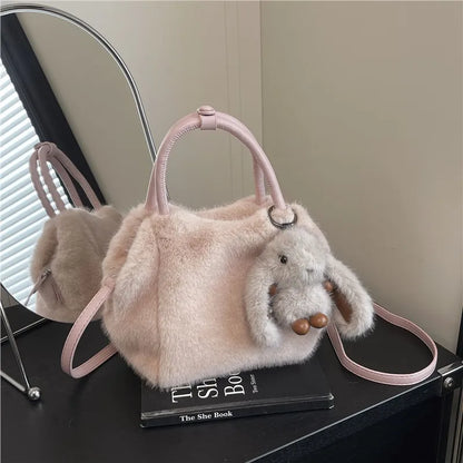 Plush top-handle handbag with rabbit charm — pale pink on books | BTendance