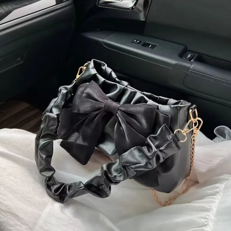 Bow-detail shoulder bag with gathered handle — black with matching bow on car seat | BTendance