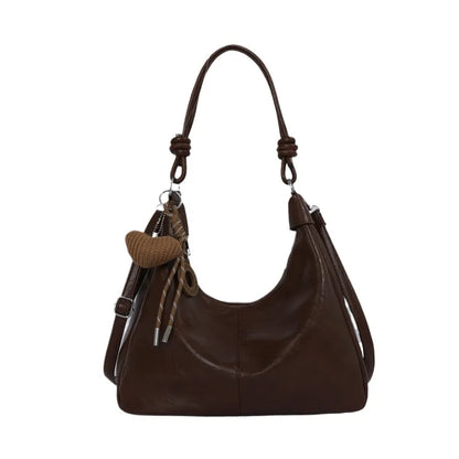 Slouchy shoulder bag with knotted strap and hanging charm — dark brown front view on white background | BTendance