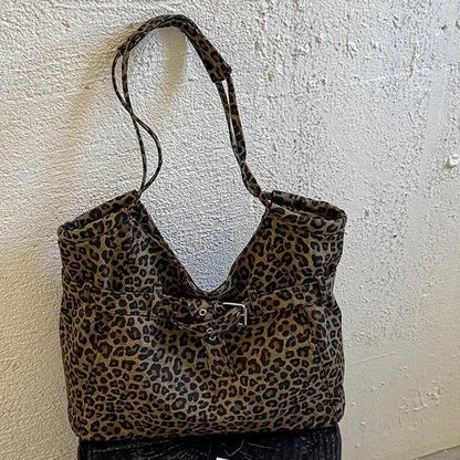 Leopard-print shoulder tote with front buckle detail — hanging against textured wall | BTendance